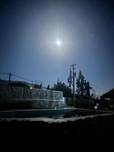 a view of a fountain at night with the moon at Cabaña Camino al Valle in La Marquesa