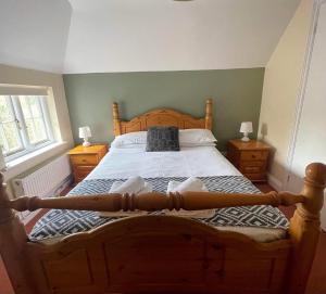 a bedroom with a large wooden bed with two lamps at Country inn in Staple