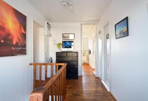 a hallway with white walls and a staircase with a dresser at Blue House B&B in Reykjavík