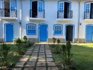 a white building with blue doors and a grass yard at San Sebastian Taipu de Fora in Marau