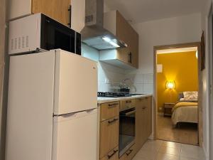 a kitchen with a white refrigerator and a stove at Gite de la Moulette in Bergerac