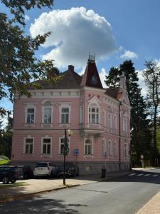 a pink building with a clock on top of it at Aparmány Rozálie in Česká Lípa
