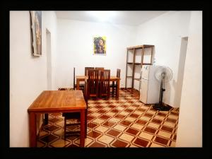 a living room with a table and a refrigerator at Bee Rooms Nosy be in Ambatoloaka