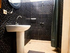 a bathroom with a sink and a shower at Bee Rooms Nosy be in Ambatoloaka