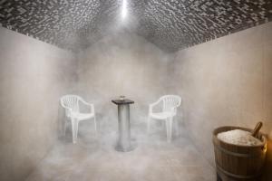 ein Zimmer mit zwei Stühlen und einem Tisch sowie ein Tisch und Stühle in der Unterkunft Olimpija Hotel & SPA in Daugavpils