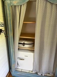 a cabinet with a curtain and a sewing machine at Romantischer Zirkuswagen in Edemissen
