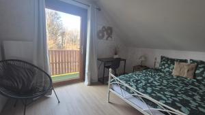 a bedroom with a bed and a large window at Les Hirondelles Chanaz in Chanaz