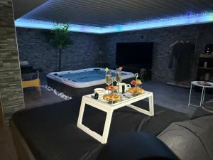 a living room with a table and a tub at Sisters spa room in Portet-sur-Garonne
