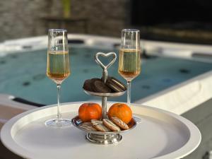 two glasses of champagne and a plate with fruit and nuts at Sisters spa room in Portet-sur-Garonne