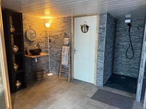 a bathroom with a walk in shower next to a brick wall at Sisters spa room in Portet-sur-Garonne