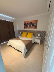 a bedroom with a bed with two yellow pillows at Mogán suite in Puerto de Mogán