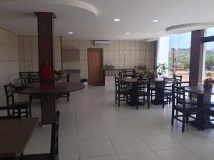 a dining room with tables and chairs in a restaurant at Gaivota Hotel in Eldorado dos Carajás