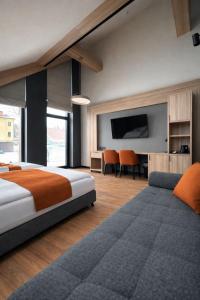 a bedroom with a bed and a couch and a tv at Ski and Bike Residence in Istebna
