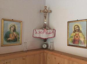 a room with two pictures and a cross on the wall at Ferienhaus Am Steindl "Steindlhof" in Schwendau