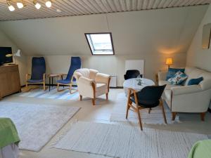 a living room with a couch and chairs and a table at Vindslägenhet på Bjäre in Båstad