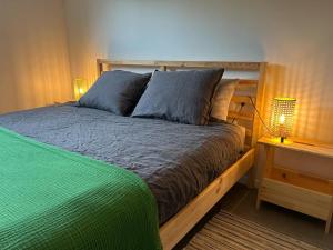 a bed in a bedroom with two lamps on a table at L'Agolum - B&B Baisy-Thy in Genappe
