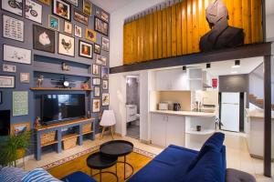 a living room with a blue couch and a kitchen at Atelier Residences by Sweet Keys in Limassol