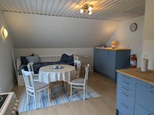 a kitchen and dining room with a table and chairs at Vindslägenhet på Bjäre in Båstad +4 photos
