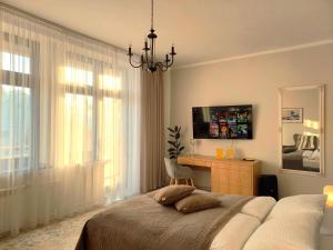 a bedroom with a bed and a desk and window at Tullu Apartament - w centrum, blisko bulwaru, blisko molo in Ostróda
