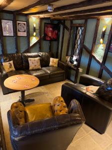 a living room with leather couches and a table at Country inn in Staple