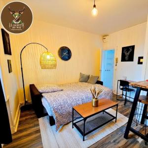 a bedroom with a bed and a table at La Cachette du Roi in Fontainebleau