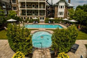 a swimming pool in front of a large building at StoneHaven Le Manoir - Relais & Châteaux in Sainte-Agathe-des-Monts