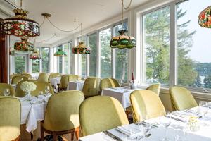 a dining room with tables and chairs and windows at StoneHaven Le Manoir - Relais & Châteaux in Sainte-Agathe-des-Monts