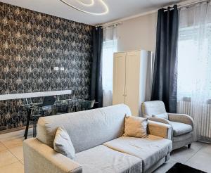 a living room with a couch and a chair at Velvet Suite - Garage Privato - Metro Dante in Turin