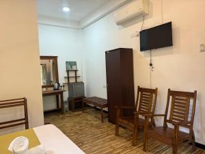 a room with two chairs and a tv on the wall at Imperial Resort in Udawalawe