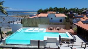 a swimming pool with a view of the ocean at Chez Max Pousada in Morro de São Paulo