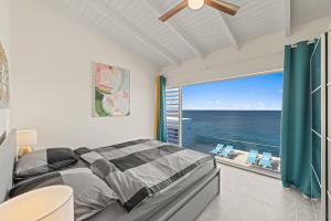 a bedroom with a bed and a large window with the ocean at Lagun Ocean View Apartments & Studio in Lagun +32 photos