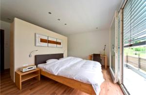 a bedroom with a bed and a large window at Hôtel de l'Etoile in Perrefitte