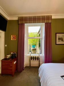 a bedroom with a bed and a window at Ravenswood Guest House in Stirling