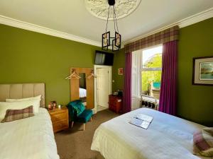 a hotel room with a bed and a window at Ravenswood Guest House in Stirling