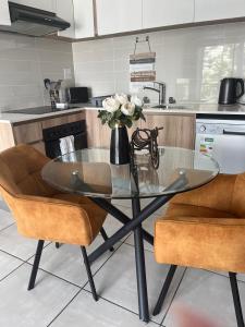 a glass table in a kitchen with a vase of flowers at Casa The Jade in Cape Town +5 photos