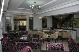 ein Restaurant mit Tischen und Stühlen und einem Kronleuchter in der Unterkunft SKG Assembly Β&Β Hotel in Thessaloniki