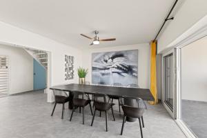 a dining room with a black table and chairs at Lagun Ocean View Apartments & Studio in Lagun
