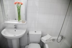 a bathroom with a toilet and a sink and a vase of flowers at Résidences Guerlin in Toulouse +65 photos