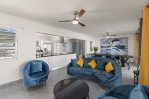 a living room with blue furniture and a kitchen at Lagun Ocean View Apartments & Studio in Lagun