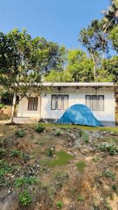 a house with a blue tarp in front of it at Munnar Clubhouse in Anachal