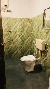 a bathroom with a toilet in a room at Munnar Clubhouse in Anachal