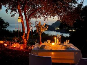 a table with candles and bottles and glasses on a table at Private villa Pyrgos - Heated Pool & Sea View - Walking distance from beaches & Liapades in Liapades