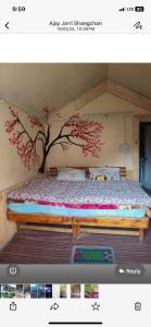 a bedroom with a tree mural on the wall at Classic hostel in Katra