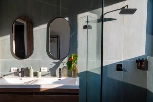 a bathroom with a sink and two mirrors at AREWÁ Biohabitat in Buenavista +33 photos
