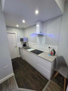a kitchen with white cabinets and a blue light at 159 Smart Apartments in Newark-on-Trent