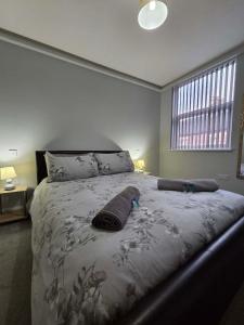 a bedroom with a bed with a blanket and a window at 159 Smart Apartments in Newark-on-Trent