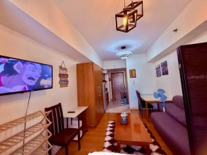 a living room with a couch and a tv on the wall at Cozy Condo in Ermita Manila near St Lukes Medical Center and US Embassy in Manila