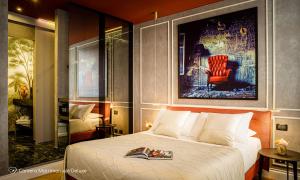 a hotel room with a bed and a red chair at Albergo Diffuso Birkin Castello in Cagliari