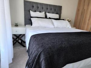 a bedroom with a large bed with a black blanket at Casa The Jade in Cape Town