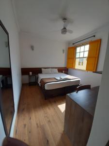 a bedroom with a bed and a window and a mirror at Imperial Cidade Smart Suítes in Ouro Preto